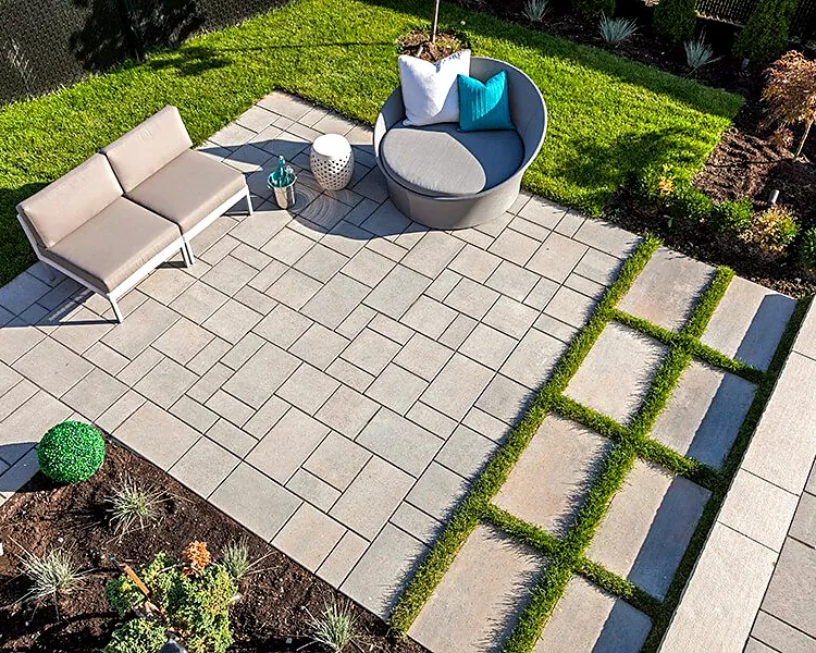 Patio walkway with grass growing in the joints between large pavers